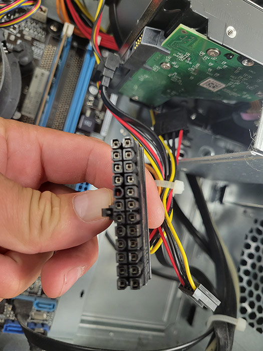 computer repair technician holding a power supply connector