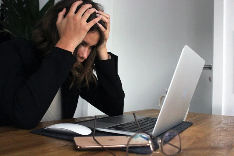 a frustrated woman experiencing IT issues on her laptop